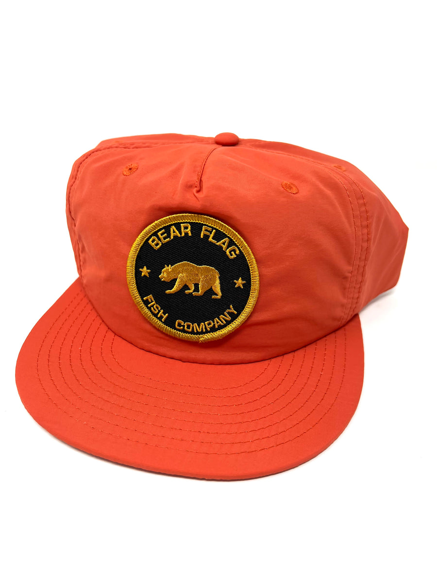 Mid profile, SnapBack cap, with gold bear in stars circle patch. Single Panel at the front, light weight, tonal under- peak lining with mesh structured support.  100% quick dry nylon, one size fits all. 
